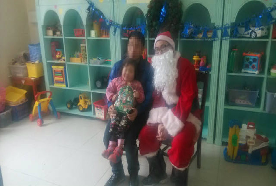 故事听完了，孩子们还意犹未尽，但是当知道要去和圣诞老人合影后，孩子们都跑得非常快，小慧是前列个跑去合影的小朋友，手上拿着刚收到的圣诞树造型的小礼物，和爸爸一起和圣诞老人留下了一张珍贵的合影。